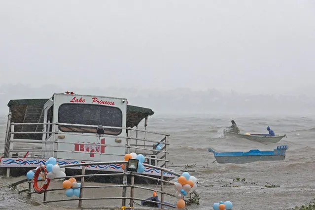 Boatmen row to rescue boats afloat amid monsoon rains at Upper lake in Bhopal on August 22, 2022. (Photo by Gagan Nayar/AFP Photo)