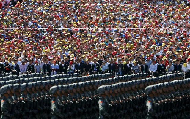 People watch soldiers of China's People's Liberation Army (PLA) marching during the military parade marking the 70th anniversary of the end of World War Two, in Beijing, China, September 3, 2015. (Photo by Damir Sagolj/Reuters)