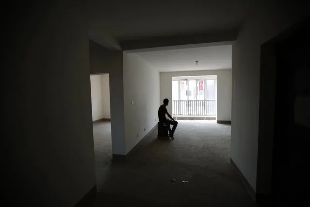 Zhiliang, whose fiancee was onboard Malaysia Airlines Flight MH370 which disappeared on March 8, 2014, is silhouetted at an empty house which he had planned to decorate with her for their marriage, after he showed the house during an interview with Reuters in Tianjin, August 26, 2014. (Photo by Kim Kyung-Hoon/Reuters)