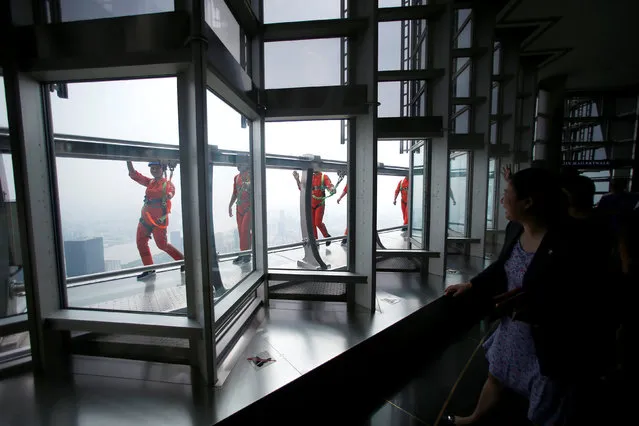 Jin Mao employees walk 340 meters above the ground around the newly opened Jin Mao tower skywalk in Shanghai, China, July 28, 2016. (Photo by Aly Song/Reuters)