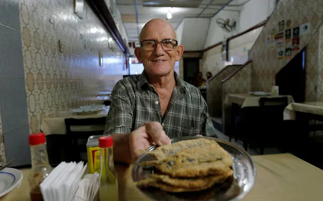 The chef shows fried sardines at the Beco das Sardinha in Rio de Janeiro, Brazil, April 12, 2016. (Photo by Sergio Moraes/Reuters)