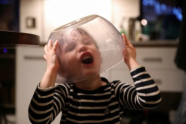Felix Hassebroek wears a salad spinner bowl and makes a face during the coronavirus outbreak in Brooklyn, New York, May 6, 2020. (Photo by Caitlin Ochs/Reuters)