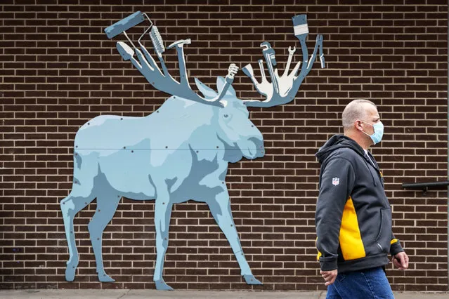 A customer leaves the Maine Hardware store where an artistic rendition of a moose, the state animal, decorates an outside wall, Friday, May 15, 2020, in Portland, Maine. Another 38 people tested positive for the new coronavirus but there were no deaths in the previous 24 hours, the Maine Center for Disease Control reported Friday. (Photo by Robert F. Bukaty/AP Photo)