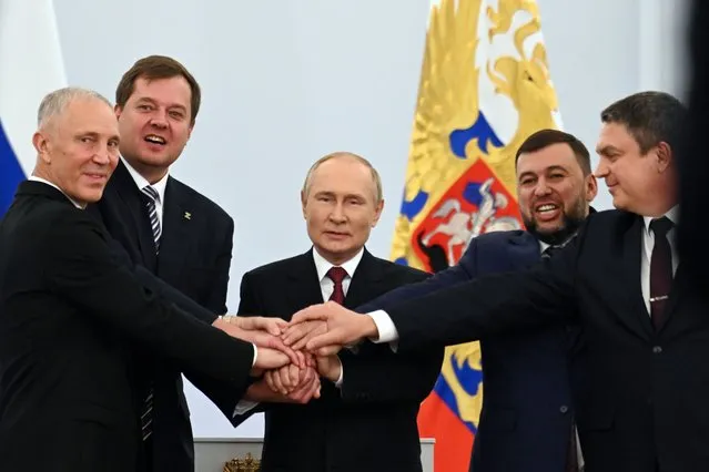 From left, Moscow-appointed head of Kherson Region Vladimir Saldo, Moscow-appointed head of Zaporizhzhia region Yevgeny Balitsky, Russian President Vladimir Putin, Denis Pushilin, leader of self-proclaimed Donetsk People's Republic and Leonid Pasechnik, leader of self-proclaimed Luhansk People's Republic pose for a photo during a ceremony to sign the treaties for four regions of Ukraine to join Russia, at the Kremlin in Moscow, Friday, September 30, 2022. The signing of the treaties making the four regions part of Russia follows the completion of the Kremlin-orchestrated “referendums”. (Photo by Grigory Sysoyev, Sputnik, Government Pool Photo via AP Photo)