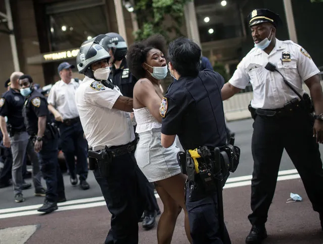 Police detain protesters in front of Trump Tower during a solidarity rally for George Floyd, Saturday, May 30, 2020, in New York. Demonstrators took to the streets of New York City to protest the death of Floyd, a black man who was killed in police custody in Minneapolis on May 25. (Photo by Wong Maye-E/AP Photo)
