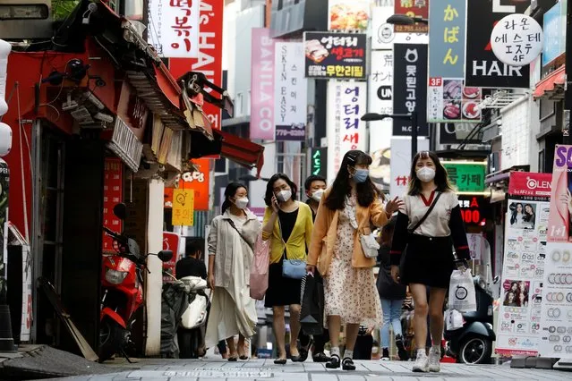 People wearing masks walk at Myeongdong shopping district amid social distancing measures to avoid the spread of the coronavirus disease (COVID-19), in Seoul, South Korea, May 28, 2020. (Photo by Kim Hong-Ji/Reuters)