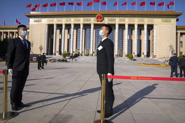 Security personnel stand outside the Great Hall of the People before the opening ceremony of the 20th National Congress of China's ruling Communist Party in Beijing, Sunday, October 16, 2022. The overarching theme emerging from China's ongoing Communist Party congress is one of continuity, not change. The weeklong meeting is expected to reappoint Xi Jinping as leader, reaffirm a commitment to his policies for the next five years and possibly elevate his status even further as one of the most powerful leaders in China's modern history. (Photo by Mark Schiefelbein/AP Photo)
