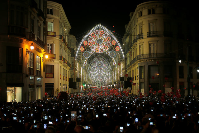 People use mobile phones to take pictures as Christmas lights are turned on to mark the start of the Christmas season at Marques de Larios street in downtown Malaga, southern Spain, November 24, 2017. (Photo by Jon Nazca/Reuters)