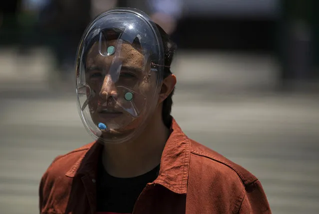 A pedestrian wears a makeshift face mask as a precaution against the spread of COVID-19, in downtown Mexico City, Friday, July 3, 2020. Limited reopening of restaurants and other businesses in the capital this week came as new coronavirus cases continued to climb steadily. (Photo by Fernando Llano/AP Photo)