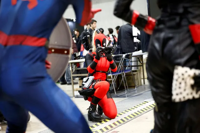 A woman in a Deadpool costume take a picture of other costume players at Tokyo Comic Con at Makuhari Messe in Chiba, Japan December 1, 2017. (Photo by Kim Kyung-Hoon/Reuters)