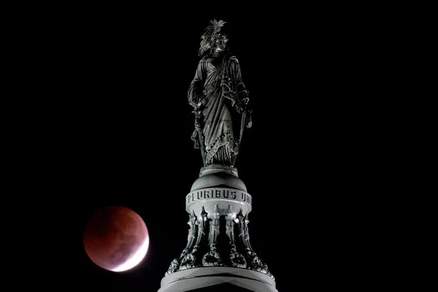 The Moon sets during a total lunar eclipse behind the Statue of Freedom on top of the US Capitol dome on the morning of the US midterm election, in Washington, DC, on November 8, 2022. (Photo by Stefani Reynolds/AFP Photo)