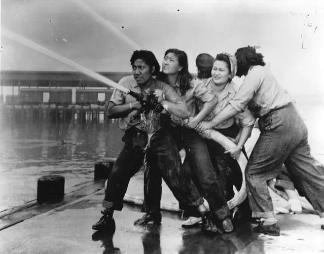 Women fire fighters directing a hose after the Japanese attack on the US naval base at Pearl Harbour (Pearl Harbor). (Photo by Three Lions/Getty Images)