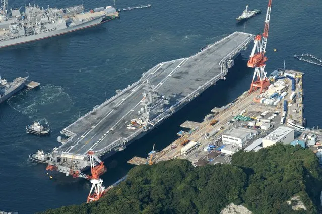 The USS Ronald Reagan, a Nimitz-class nuclear-powered super carrier, arrives at the U.S. naval base in Yokosuka, south of Tokyo, Japan, in this aerial view photo taken by Kyodo October 1, 2015. The U.S. nuclear powered aircraft carrier arrived at the Japanese port of Yokosuka on Thursday, a day earlier than expected. (Photo by Reuters//Kyodo News)