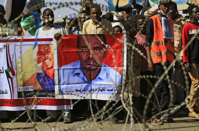 Sudanese protesters rally in front of a court in Omdurman near the capital Khartoum, on December 30, 2019, during the trial of intelligence agents for the death of teacher Ahmed Al-Khair (portrait R) while in custody of intelligence services. The court sentenced 27 intelligence agents to death by hanging, for torturing and killing the teacher at an intelligence services facility during protests a year ago, judge Sadok Albdelrahman said. (Photo by Ashraf Shazly/AFP Photo)