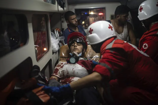 An injured demonstrator is taken by an ambulance after clashes with police during an anti-government protest, following last week's massive explosion which devastated Beirut, Lebanon, Tuesday, August 11, 2020. (Photo by Felipe Dana/AP Photo)