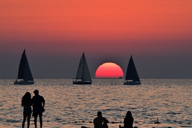 Boats sail at sunset in the Gulf emirate of Dubai, on March 19, 2025, during Islam's fasting month of Ramadan. (Photo by Giuseppe Cacace/AFP)