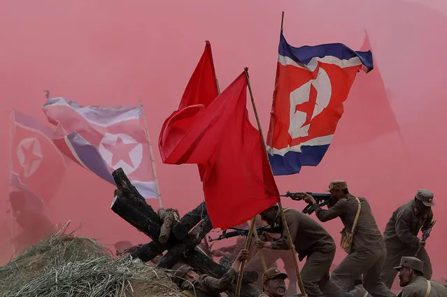 South Korean soldiers wear North Korea's military uniforms and hold North Korea's flags, acting as North Korean soldiers, as they take part in a re-enactment the battle of the Korean war during a commemorative war victory event to mark the 66th anniversary of the the Korean war on September 22, 2016 in Waegwan, South Korea. Korean and US soldiers participated in the event alongside the Korean war veterans from both countries. (Photo by Chung Sung-Jun/Getty Images)