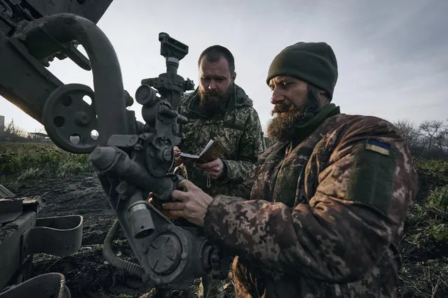 Ukrainian servicemen prepare to fire at Russian positions in the frontline near Bakhmut, Donetsk region, Ukraine, Thursday, November 24, 2022. (Photo by LIBKOS/AP Photo)