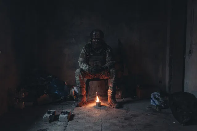 A Ukrainian soldier warms himself with a candle in a house at his position on the Donbass frontline, in Donetsk Oblast, Ukraine on January 14, 2023. (Photo by Diego Herrera Carcedo/Anadolu Agency via Getty Images)