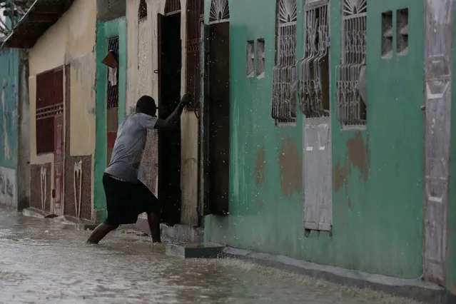 A man enters a house on a flooded street while Hurricane Matthew passes through Port-au-Prince, Haiti, October 4, 2016. (Photo by Carlos Garcia Rawlins/Reuters)