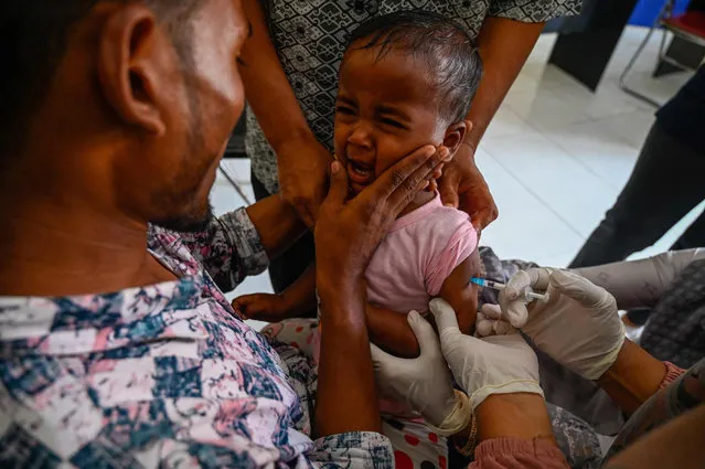 A young Rohingya refugee reacts while receiving polio and rubella vaccines organized by the International Organization for Migration (IOM) at a temporary shelter in Ladong, Aceh province on January 27, 2023. (Photo by Chaideer Mahyuddin/AFP Photo)