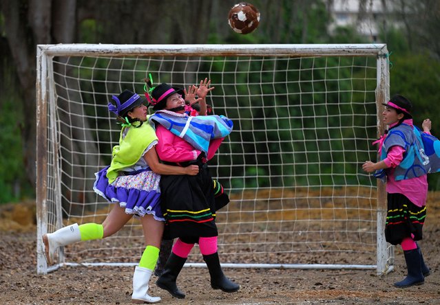 Players of Rubas (in blue) and Jenesano (in green) fight for the ball in a football tournament during the Botas, Ruana and Sombrero cultural and sport festival in Jenesano, Boyaca department, Colombia on August 18, 2025. Eight female teams of residents and farmers from Jenesano, a rural village in the mountains of Colombia, participate every year in the amateur football tournament called “Botas, Ruana y Sombrero” (Boots, ruana and hat), in which they play wearing traditional clothing. (Photo by Luis Acosta/AFP Photo)