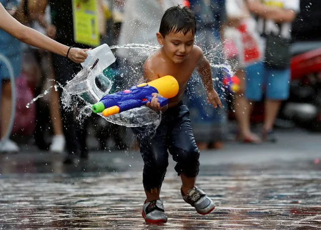 A boy plays with water, during the Songkran Water Festival celebrations, to commemorate the Thai New Year in Bangkok, Thailand April 12, 2018. (Photo by Soe Zeya Tun/Reuters)