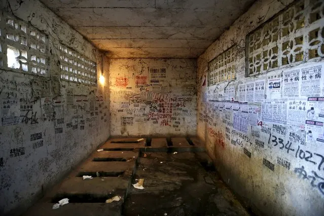 Posters, including those advertising treatments for sexually transmitted diseases, are stuck to the walls of a public toilet in a residential area for migrant workers in Shigezhuang village, Beijing, China, October 13, 2015. (Photo by Jason Lee/Reuters)