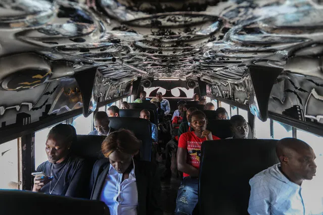 Passengers ride a matatu named “Batman” painted with graffiti, fitted with batman theme interior, screens and sound system look on as they travel home during a rush hour in the streets of Nairobi, Kenya, 04 April 2018. Kenya is known to have public service vehicles especially the mini buses decorated with graffiti, interior design, loud music and flat screens that gives it the atmosphere of a disco as a way of attracting customers. (Photo by Daniel Irungu/EPA/EFE)
