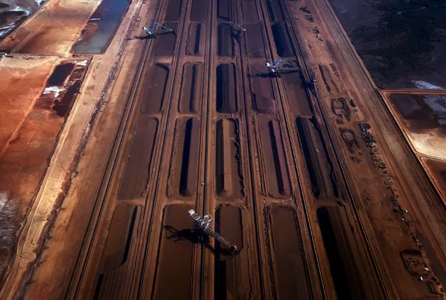 Bucket-wheel reclaimers move iron ore at a loading terminal in the town of Port Hedland, located in the Pilbara region of Western Australia in this December 3, 2013 file photo. Australia is expected to release GDP data this week. (Photo by David Gray/Reuters)