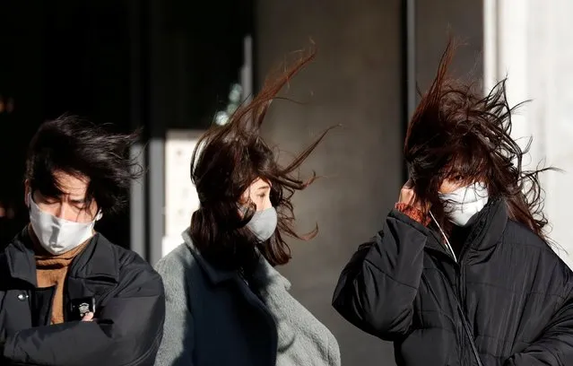 Pedestrians, wearing protective masks against COVID-19, stand in strong wind in Tokyo, Japan, January 7, 2021. Japanese Prime Minister Yoshihide Suga declared a state of emergency Thursday for Tokyo and three other prefectures to ramp up defenses against the spread of the coronavirus. (Photo by Kim Kyung-Hoon/Reuters)
