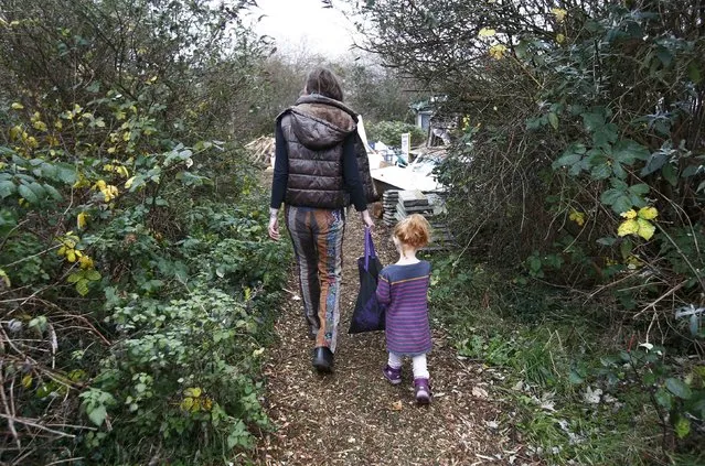 An anti-Heathrow expansion activist and a child walk through the 'Grow Heathrow' protest camp in the village of Sipson near to Heathrow Airport, west London Britain December 7, 2015. (Photo by Peter Nicholls/Reuters)