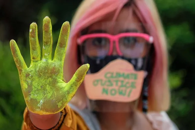 A Filipino climate activist wearing a face shield with the words “Climate Justice Now” poses showing her hand as part of global climate change protests, in Quezon City, Metro Manila, Philippines on September 25, 2020. (Photo by Eloisa Lopez/Reuters)