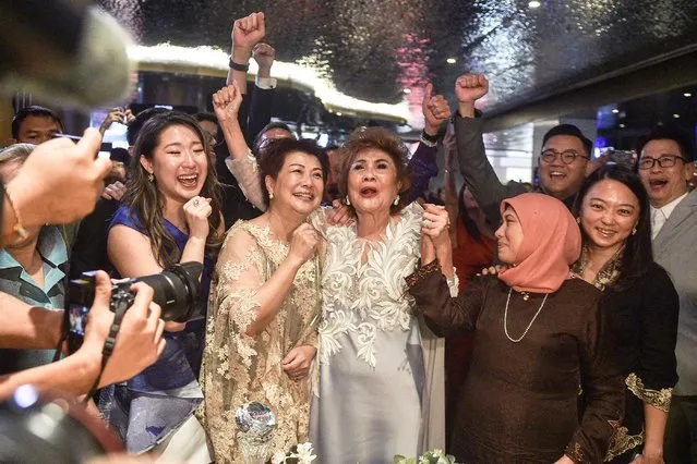 Janet Yeoh (centre R), mother of actress Michelle Yeoh, celebrates after her daughter won the award for Best Actress in a Leading Role at the 95th Academy Awards in Los Angeles, at an event in Kuala Lumpur on March 13, 2023. (Photo by Arif Kartono/AFP Photo)