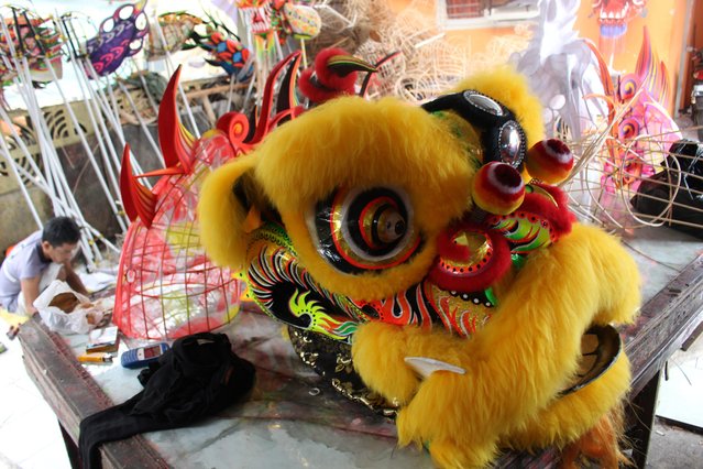 An Indonesian worker checks a  barongsai (lion dance) mask for the upcoming Lunar New Year at a traditional Chinese dragon and lion masks and custome maker in Bogor, Indonesia, 02 February 2015. (Photo by Adi Weda/EPA)