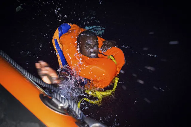 A migrant swims frantically towards a rescue ship off the coast of Libya in the early hours of Thursday night, August 2, 2018. Rescuers from the Spanish non -profit Open Arms saved 87 migrants off the coast of Libya in a dramatic nighttime operation. The group included eight minors. (Photo by Valerio Nicolosi/AP Photo)