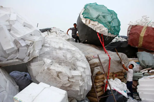 Men pile up styrofoam at a recycling yard at the edge of Beijing, China, September 21, 2016. (Photo by Thomas Peter/Reuters)