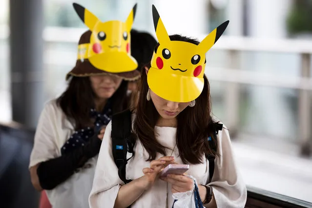Women wearing paper visors of Pikachu, a character from Pokemon series game titles, use smartphones as they arrive for  the Pikachu Outbreak event hosted by The Pokemon Co. on August 10, 2018 in Yokohama, Kanagawa, Japan. (Photo by Tomohiro Ohsumi/Getty Images)