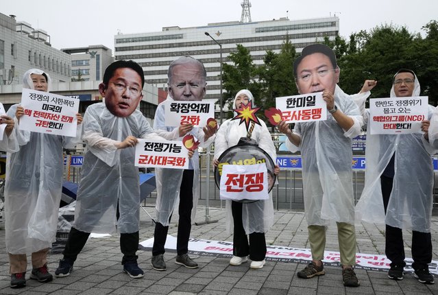 Protesters wearing masks of Japanese Prime Minister Fumio Kishida, second from left, U.S. President Joe Biden and South Korean President Yoon Suk Yeol, second from right, attend a rally against a meeting of Nuclear Consultative Group between South Korea and the United States in front of the presidential office in Seoul, South Korea, Tuesday, July 18, 2023. A bilateral consulting group of South Korean and U.S. officials met Tuesday in Seoul to discuss strengthening their nations' deterrence capabilities against North Korea's evolving nuclear threats. The signs read “Disintegration of Nuclear Consultative Group”. (Photo by Ahn Young-joon/AP Photo)