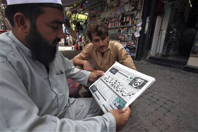 Pakistani men reads a local newspaper carrying headline news of the Pakistan's former Prime Minister Imran Khan, in Peshawar, Pakistan, Sunday, August 6, 2023. Khan was arrested Saturday after a court handed him a three-year jail sentence for corruption, a development that could end his future in politics. (Photo by Mohammad Sajjad/AP Photo)