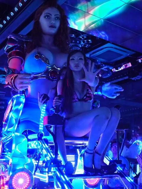 Bikini-clad women sit as they operate a 3.6 metre-high custom-made female robot at the newly opened “Robot Restaurant” in Kabukicho, one of Tokyo's best known red light districts. (Photo by Tokyo Scum Brigade)
