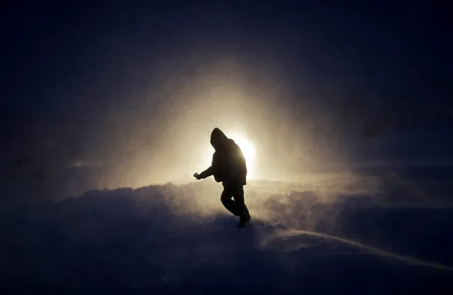 In this Tuesday, November 29, 2016, photo, a person walks through a snow storm at the Oceti Sakowin camp where people have gathered to protest the Dakota Access oil pipeline in Cannon Ball, N.D. Those in the camp have shrugged off the heavy snow, icy winds and frigid temperatures. But if they defy next week's government deadline to abandon the camp, demonstrators know the real deep freeze lies ahead. (Photo by David Goldman/AP Photo)