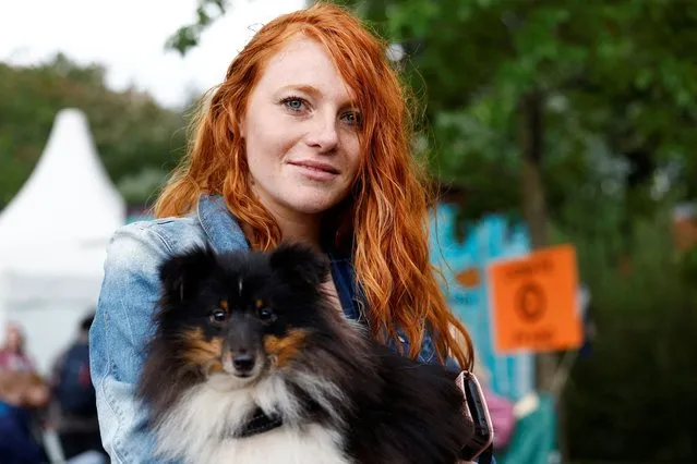 A woman, 35, from Zeeland, holds a dog as she attends the annual Redhead Days Festival in Tilburg, Netherlands on August 27, 2023. (Photo by Piroschka van de Wouw/Reuters)