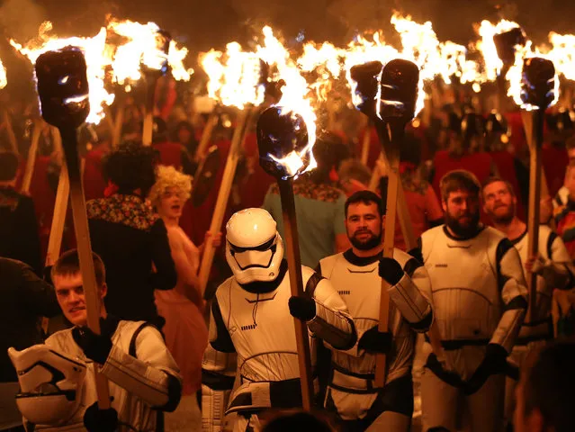 People dressed as Storm Troopers from the Star Wars films carry flaming torches during the Up Helly Aa Viking festival in Lerwick on the Shetland Isles, Scotland, Tuesday January 26, 2016. (Photo by Andrew Milligan/PA Wire via AP Photo)
