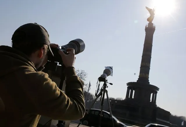 A man photographs the partial solar eclipse beside the “Golden Victoria” statue on top of the Victory Column (Siegessaule) in Berlin March 20, 2015. (Photo by Fabrizio Bensch/Reuters)