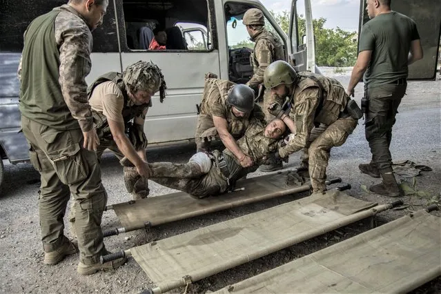 Ukrainian servicemen evacuate a wounded soldier from the battlefield into an ambulance during heavy shelling in Siversk, Ukraine on July 05, 2022. (Photo by Narciso Contreras/Anadolu Agency via Getty Images)