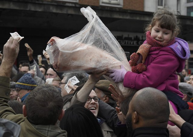 Shoppers react as they bid for cuts of meat at a butchers during a Christmas eve auction in Smithfield market London, Britain, December 24, 2016. (Photo by Toby Melville/Reuters)