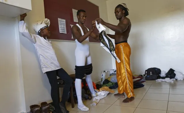 In this photo taken Friday, December 9, 2016, Kenyan ballet dancer Joel Kioko, 16, center, is helped to put on his costume by dance teacher Victor Mishael Okumu, right, before a performance of The Nutcracker in Nairobi, Kenya. (Photo by Ben Curtis/AP Photo)