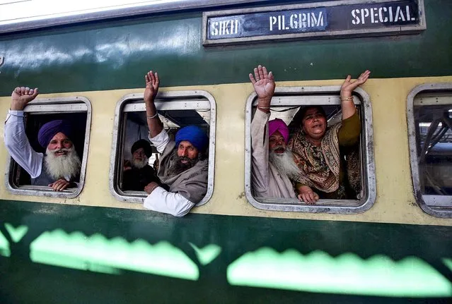 Pilgrims wave from a train headed to Pakistan, at a railway station in the northern Indian city of Amritsar, on November 15, 2013. Hundreds of Sikhs from various parts of India are traveling to Pakistan to visit the shrine of Nankana Sahib, the birthplace of Sikh faith founder Guru Nanak Dev, to celebrate the anniversary of his birth. (Photo by Munish Sharma/Reuters)