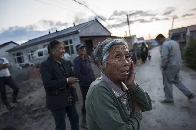 Residents gather and talk in the streets of Liumao, China on May 29, 2016. Liumao sits below BTR, a large graphite mine and factory. Residents of Liumao who live in proximity to the factories complain of contaminated air and water affecting their crops and health. (Photo by Michael Robinson Chavez/The Washington Post)